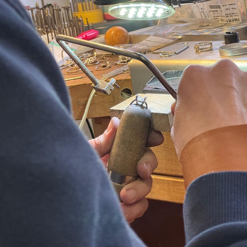 Joaillier sciant une monture à la cheville de l'établi